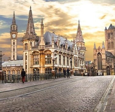 Historic medieval architecture of Ghent, Belgium, featuring Saint Bavo's Cathedral at sunset.