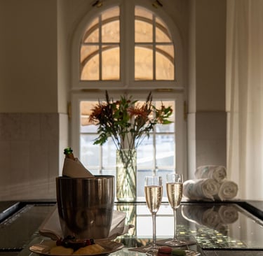 Luxury spa experience with champagne, macarons, and flowers by an indoor pool.
