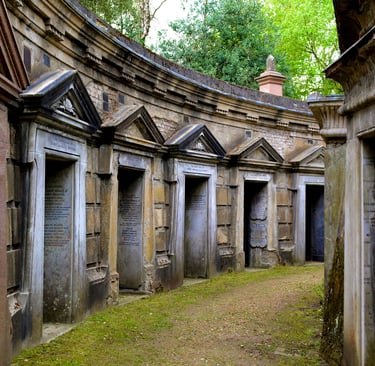 Historic Victorian stone family mausoleums and tombs at Highgate Cemetery in London.
