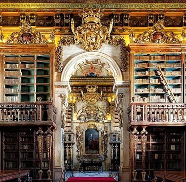 The ornate Baroque interior of the Joanina Library in Coimbra, Portugal, featuring gilded wood bookshelves.