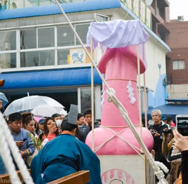 Crowds gather around a large pink phallus float at the Kanamara Matsuri festival in Kawasaki, Japan.