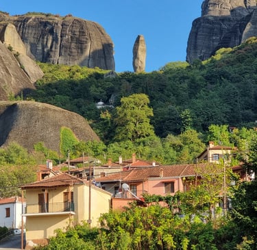 Kastraki village houses below the towering Meteora rock formations and vertical cliffs in Greece.