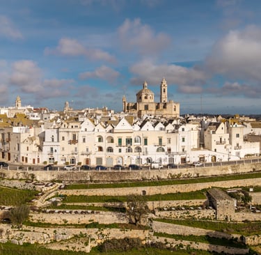 Aerial view of Locorotondo, Puglia, featuring white houses and the San Giorgio Church in Italy.