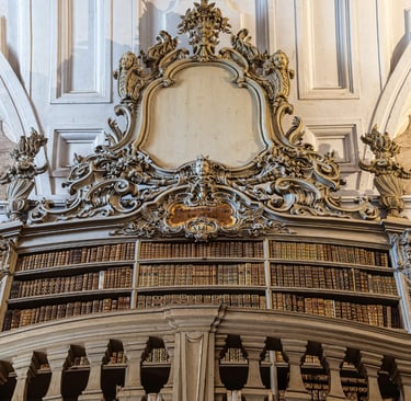 Ornate baroque architecture in a historic library with gold-trimmed bookshelves and intricate carvings.