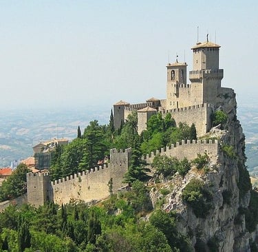 The historic Guaita Tower fortress sits atop Mount Titano in San Marino overlooking the valley.
