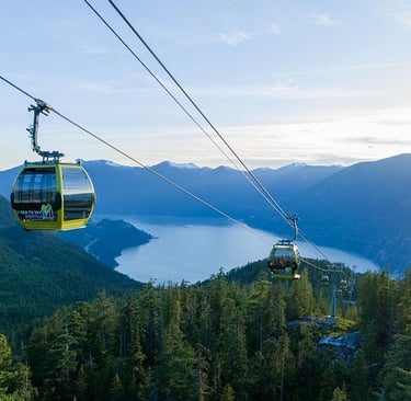 Yellow Sea to Sky Gondola cabins overlooking Howe Sound and coastal mountains in Squamish.
