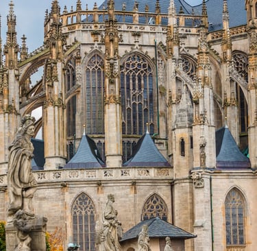 Gothic architecture of St. Barbara's Cathedral in Kutna Hora with ornate flying buttresses and stone statues.