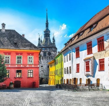 Colorful medieval buildings and the historic Clock Tower in Sighisoara Citadel, Romania.
