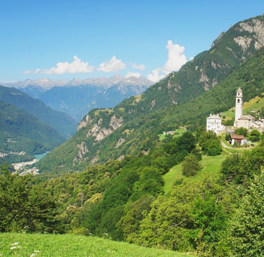 Panoramic view of a scenic mountain village in the Swiss Alps with a historic stone church.