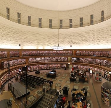 Panoramic view of the circular Stockholm Public Library interior with multi-level bookshelves and rotunda design.