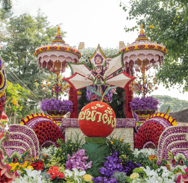 Vibrant Chiang Mai Flower Festival float featuring ornate Naga sculptures and traditional Thai floral displays.