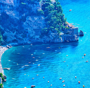 Aerial view of boats in the turquoise water of the Amalfi Coast near Positano beach in Italy.