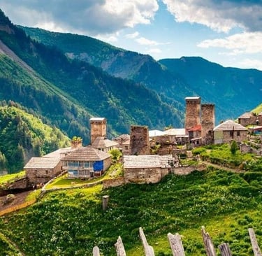 Historic stone Svan towers in a lush mountain village in the Svaneti region of Georgia.