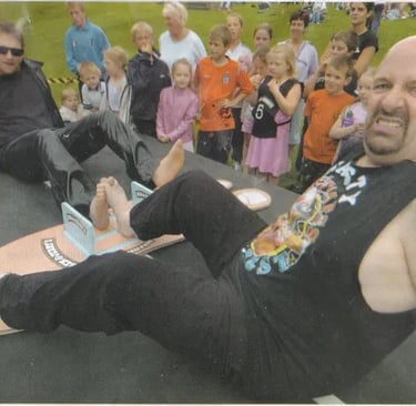 Two men compete in a competitive toe wrestling match on a platform in front of a crowd of spectators.