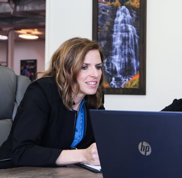 a woman sitting at a table with a laptop