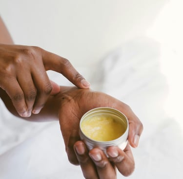a person holding a box of body cream in their hands