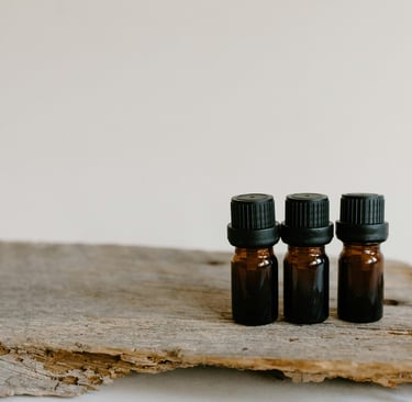three bottles of essential oils on a wooden surface
