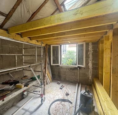 a lofted room under renovation works with large wood structure