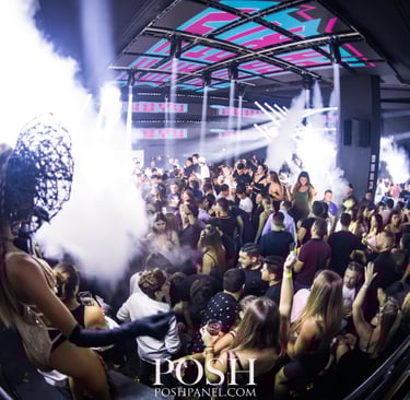 a crowd of people standing around a dj booth, rico sanchez performance at La V in Miami