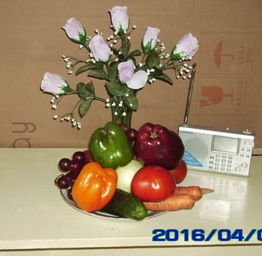 一盘水果，一个花瓶，和一个收音机。