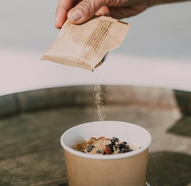artificial sweetener poured out of packet on fruit dessert