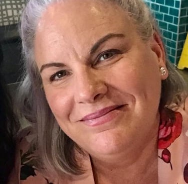 a woman with grey hair and a pink shirt
