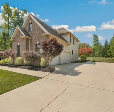 a house with a  concrete driveway and garden