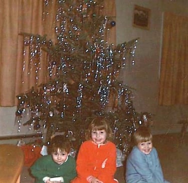 Derek, Karen and me in our "Sleepers". I am guessing 1974 or '75. Christmas morning by the tree.
