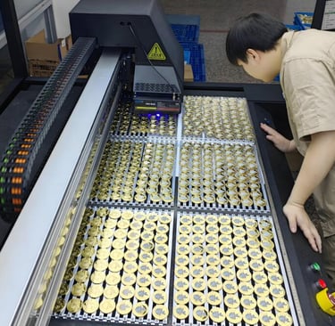 The worker is inspecting at a tray of enamel pins