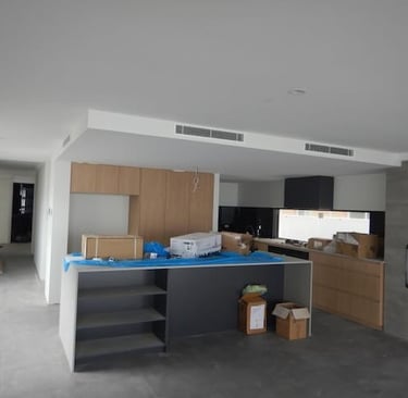 Registered builder conducting detailed building inspection in Perth home, assessing roof structure and wall alignment.