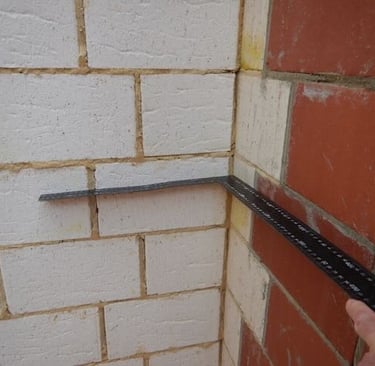 Professional inspector performing AS 4349.1-compliant building inspection Perth, reviewing foundations and brickwork.