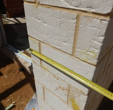 Close-up of Perth building inspector checking brickwork defects and Australian Standards references
