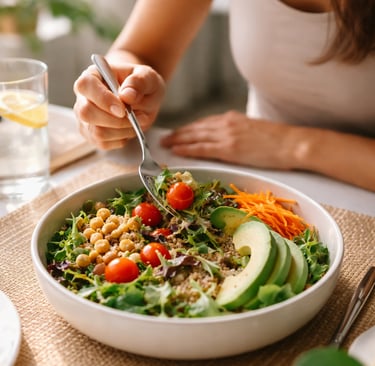 Mulher comendo salada de forma consciente à mesa, representando atenção alimentar e a prática de com
