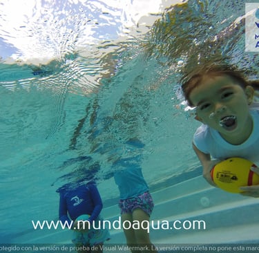a young girl is playing with a ball in the water