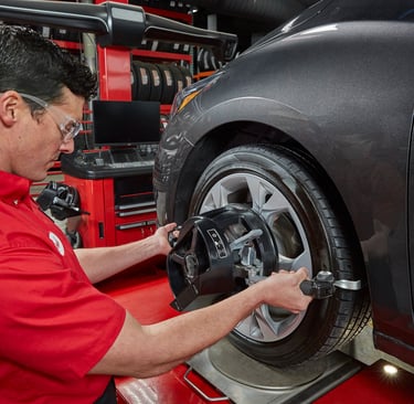 A Big O Tires employee changing a tire