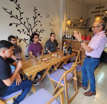 a man standing in front of a table with wine glasses and wine glasses