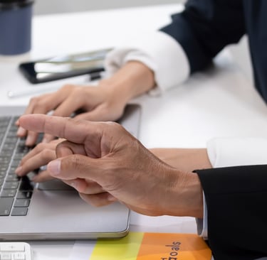 a man and woman sitting at a desk with a laptop