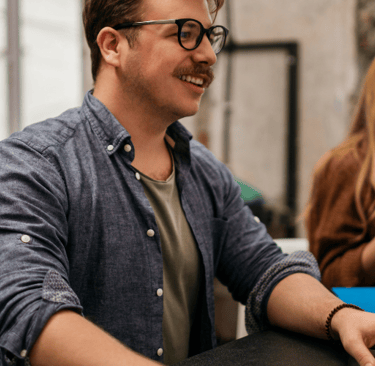a man sitting at a desk with a woman in a blue shirt