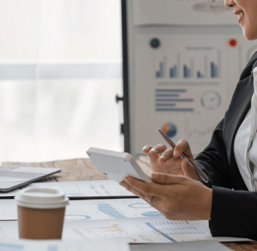 woman at computer with calculator and pen in hands