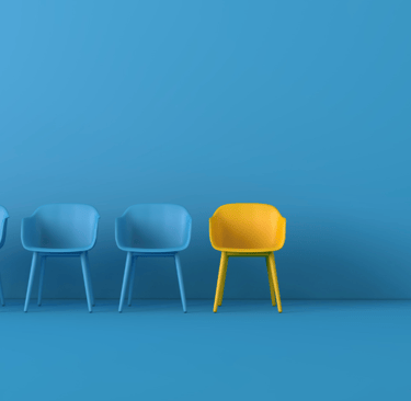 a row of chairs with a yellow chair and a blue wall