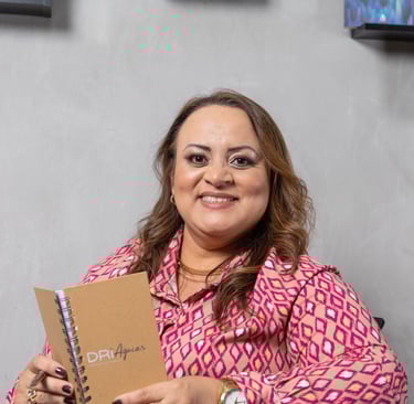 a woman in a pink shirt is holding a notebook and smiling