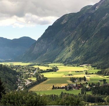 the sun shines on a valley with mountains in the distance