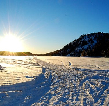 snow on a frozen lake with the sun on the horizon-flikr cite