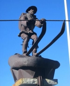 a sculpture of a man skiing wearing a hat and pack