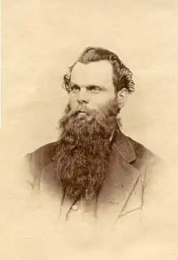 a black and white photo of a man with wild hair and a long beard