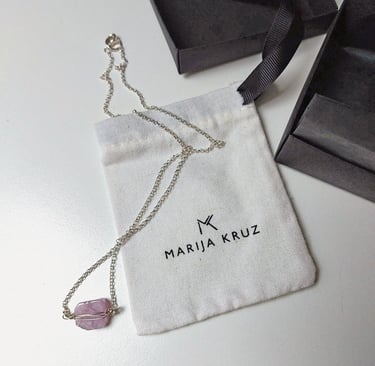 pakabukas su rausvu akmeniu šalia marija kruz vardinio maišelio