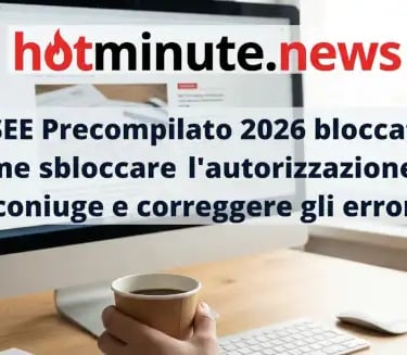 a person holding a cup of coffee in front of a computer screen