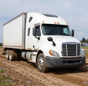 A nighttime roadside lockout service with a technician using specialized tools under truck lights.