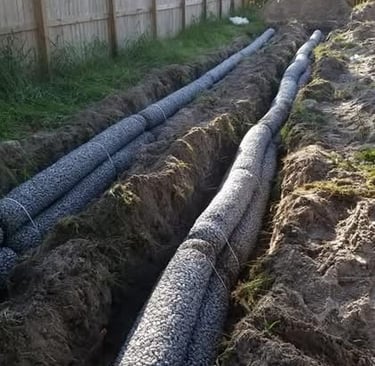 2 trenches dug with septic drainage pipe laid in it