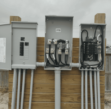 Three electrical control panels side by side and mounted on a wooden support a wooden